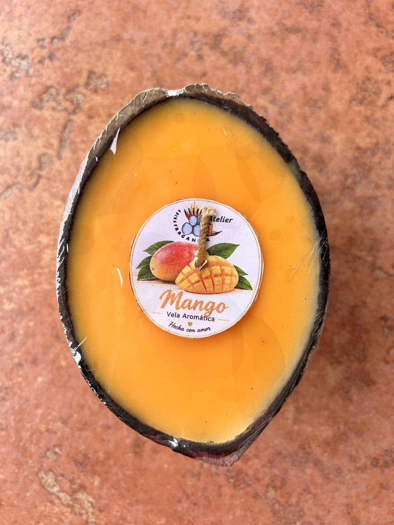 Vela aromática de mango, color naranja, en su recipiente artesanal